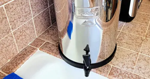 Berkey water filter on kitchen counter next to kitchen sink.