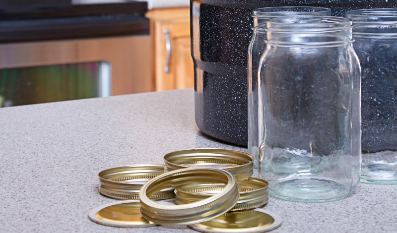 Canning jars, lids and water bath pot on a kitchen counter