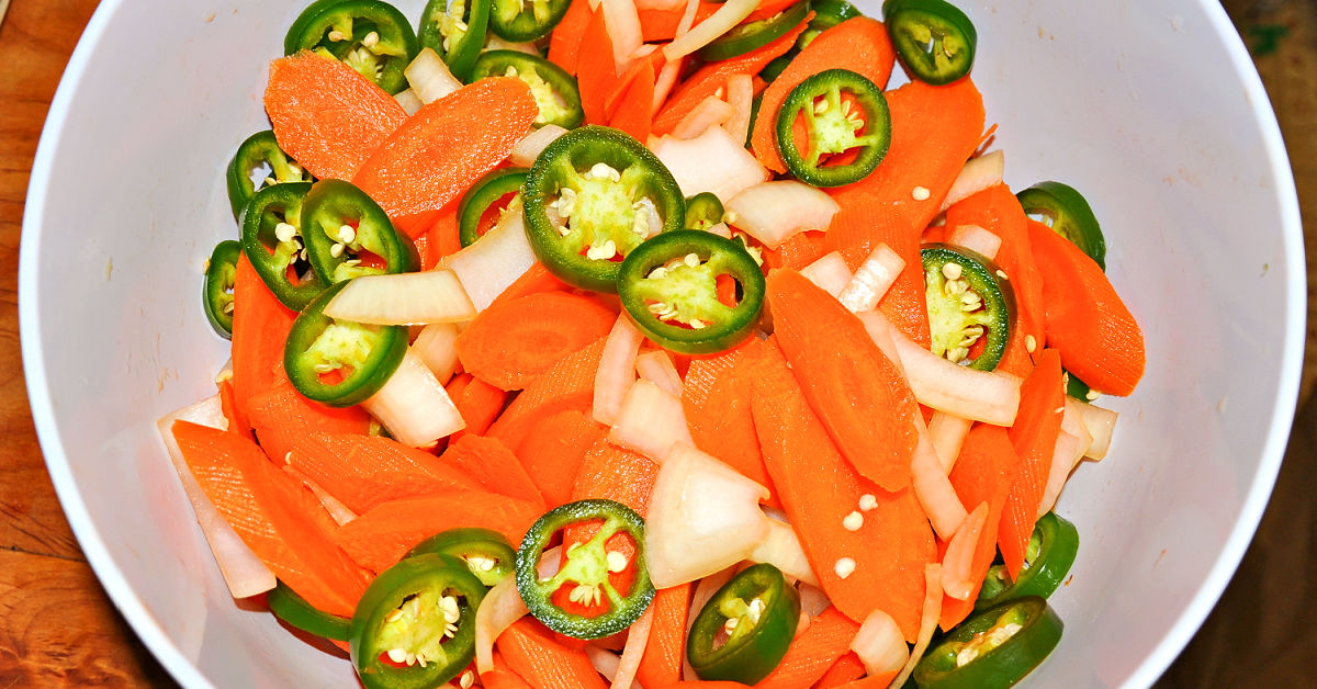 Sliced carrots, onions and jalapenos in a bowl