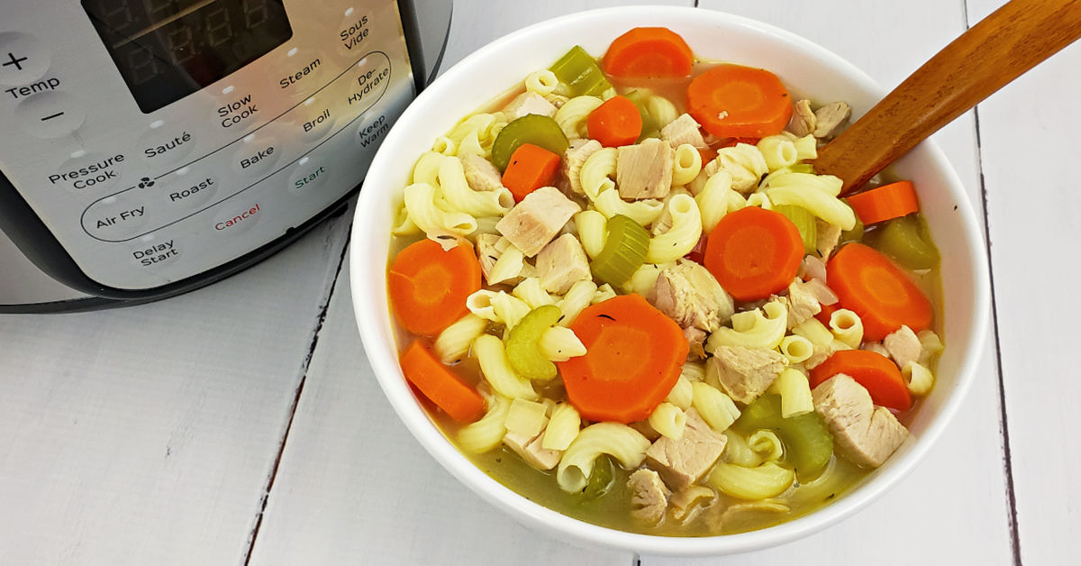 Gluten free chicken noodle soup served with ladle next to Instant Pot.