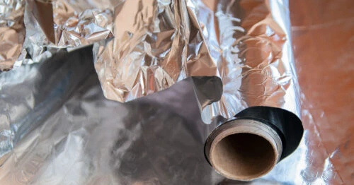 Roll of wrinkled aluminum foil that's unwinding itself.