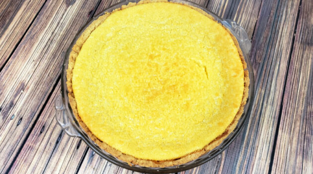 Baked gluten free buttermilk pie cooling on a wood table.
