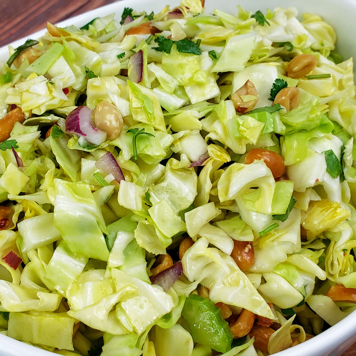 Asian slaw with cabbage, red onion, celery, peanuts and fresh herbs.