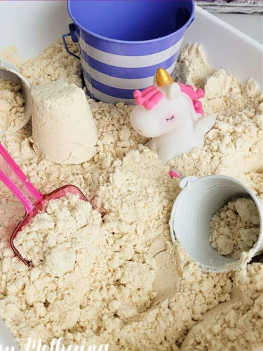 Moon sand in a white tub with a unicorn, pink scoop, and buckets for making sand castles.