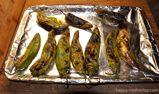Blackened hatch chiles on a foil lined baking pan