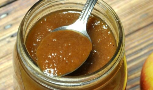 Close up of crock pot apple butter in jar on table