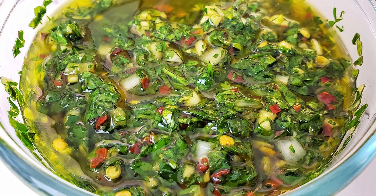 Bowl of chimichurri sauce on the table to serve with meat.