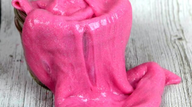 Close up of pink slime spilling out of a glass jar