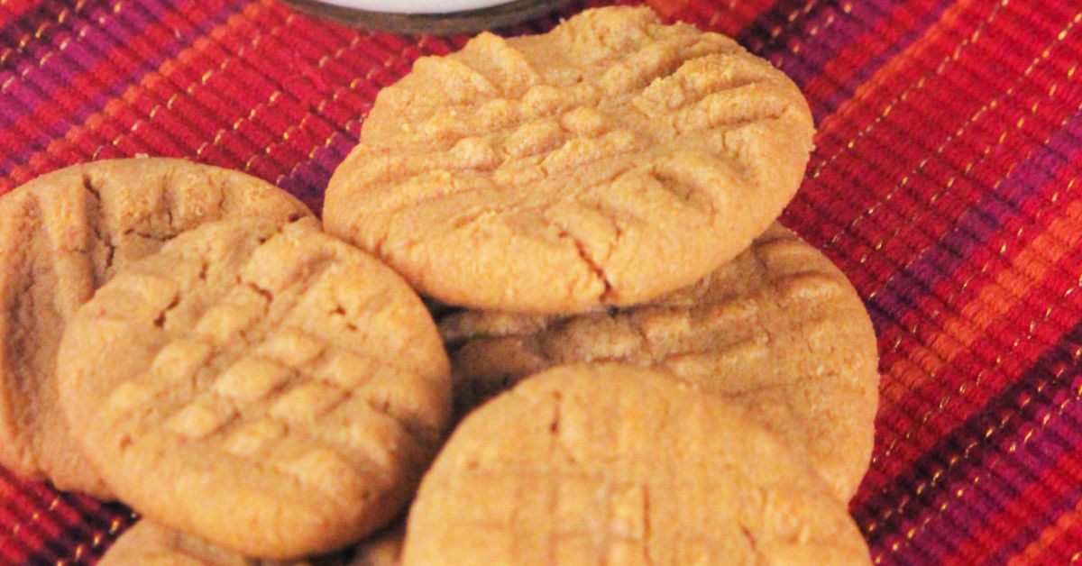 Close up of homemade gluten free peanut butter cookies on red tablecloth.