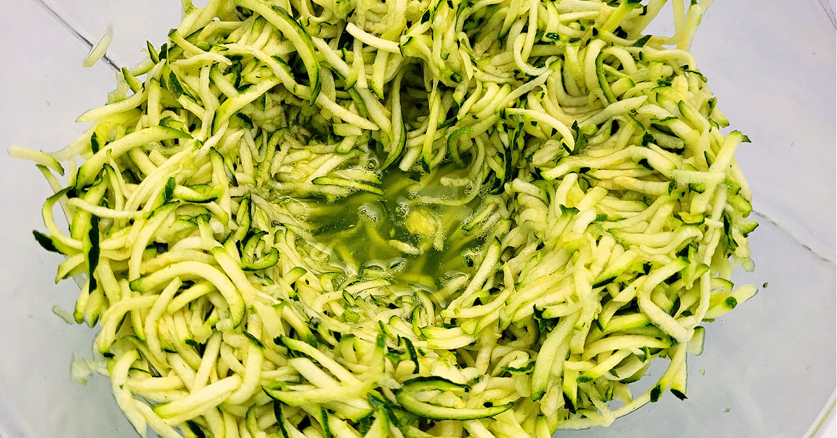 Shredded zucchini after resting with salt mixed in produces liquid.