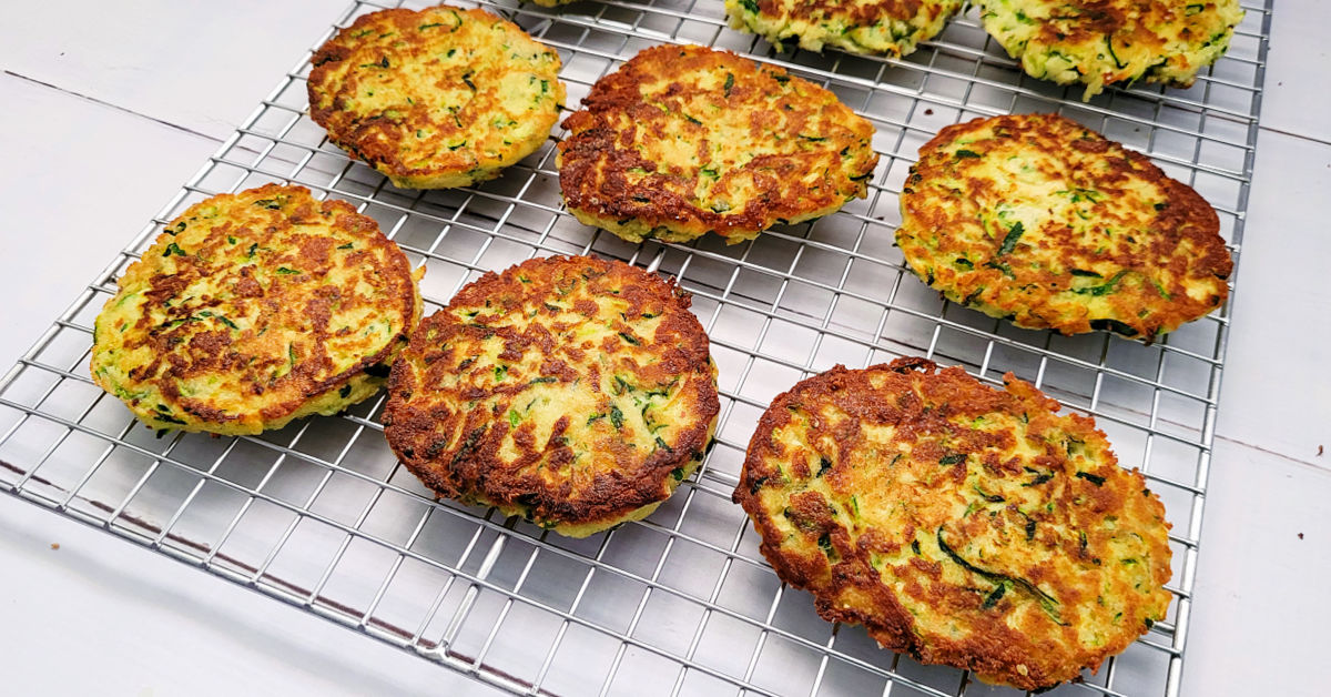 Golden brown gluten free zucchini fritters on a wire cooling rack.