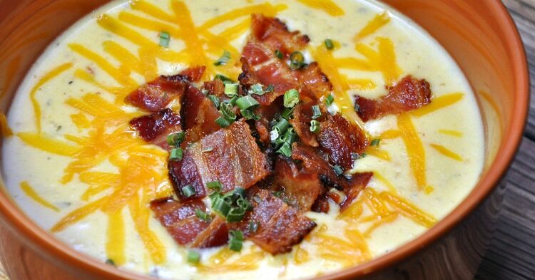 Bowl of Instant Pot Cauliflower Soup topped with bacon, cheddar and chives