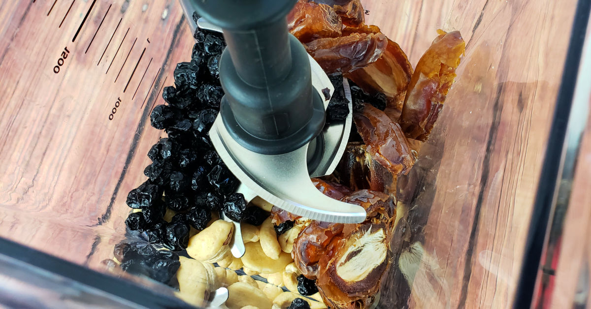 Dates, cashews, and dried blueberries in blender pitcher.