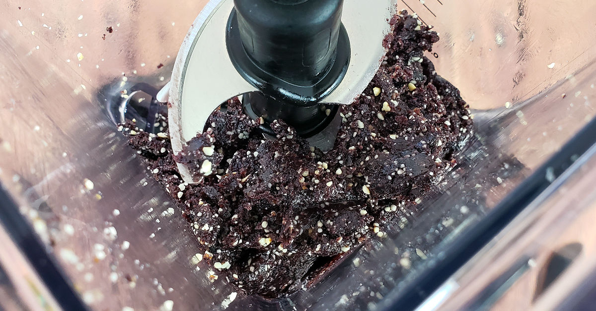 Dates, cashews and blueberries blended into a paste in a blender.
