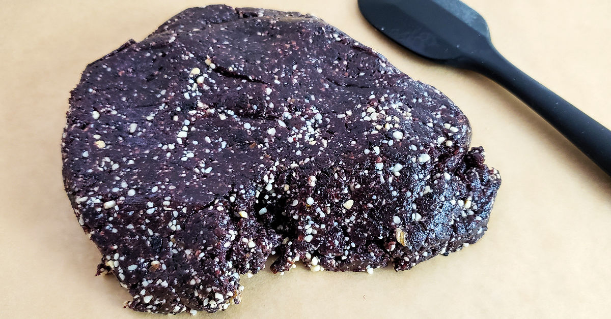Blueberry Cashew Date paste on a parchment paper lined cookie sheet.
