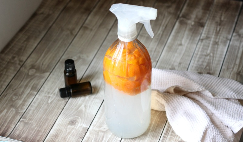 All purpose cleaner on table with towel and essential oils.