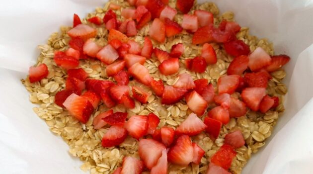 Diced strawberries sprinkled over the oatmeal crust