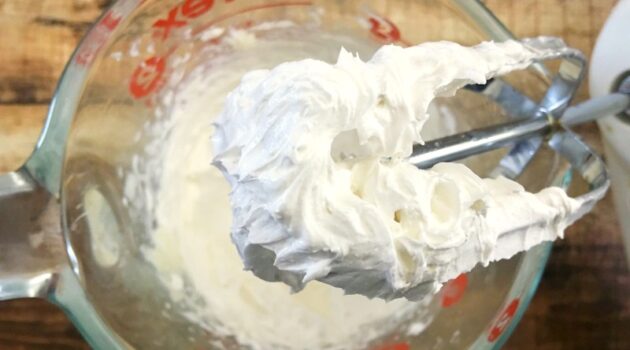 DIY shaving cream being whipped up in a glass measuring cup