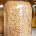 Quart sized mason jar of homemade Cajun Seasoning in a spice cabinet
