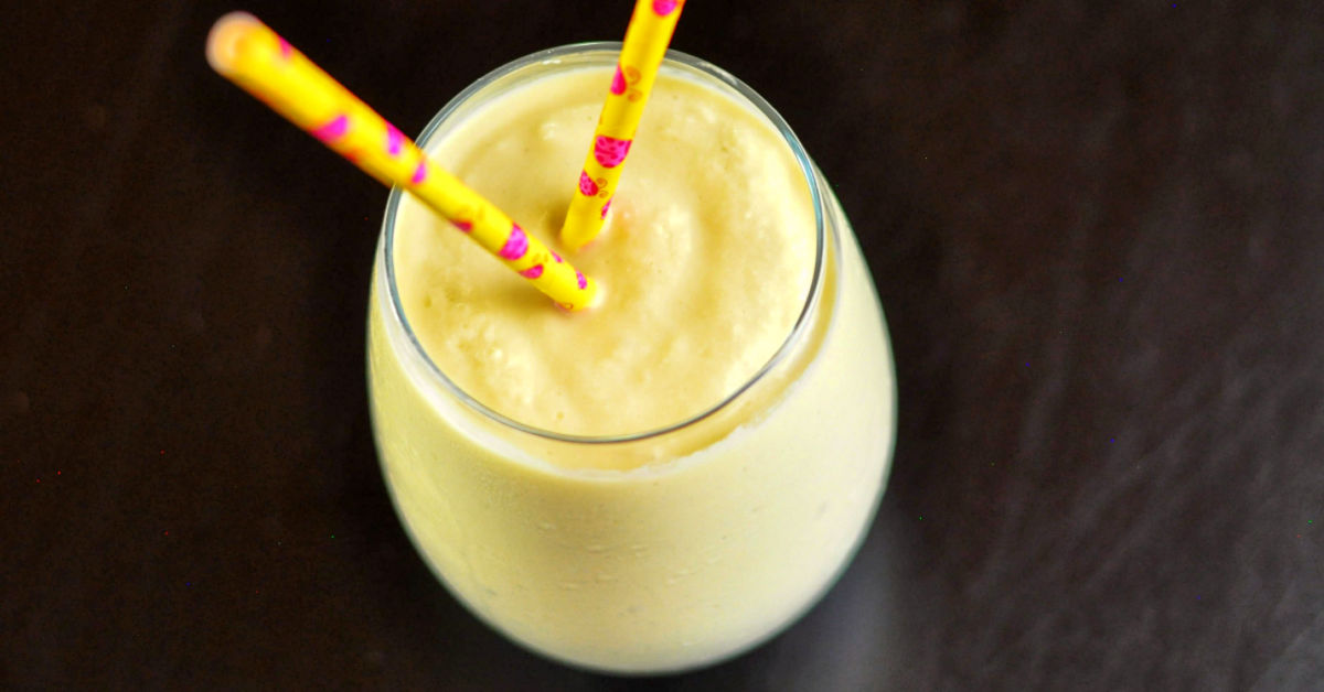 Overhead view of Mango Pineapple served in a glass with two yellow paper straws.