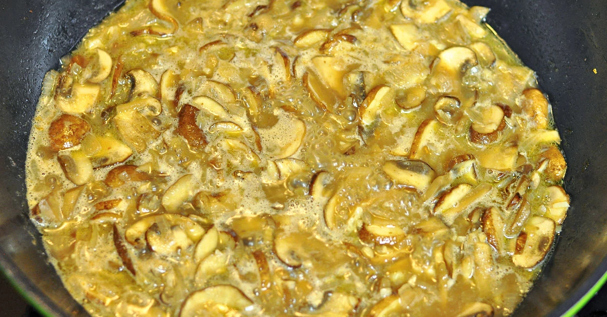 Marsala mushroom sauce simmering in pan.