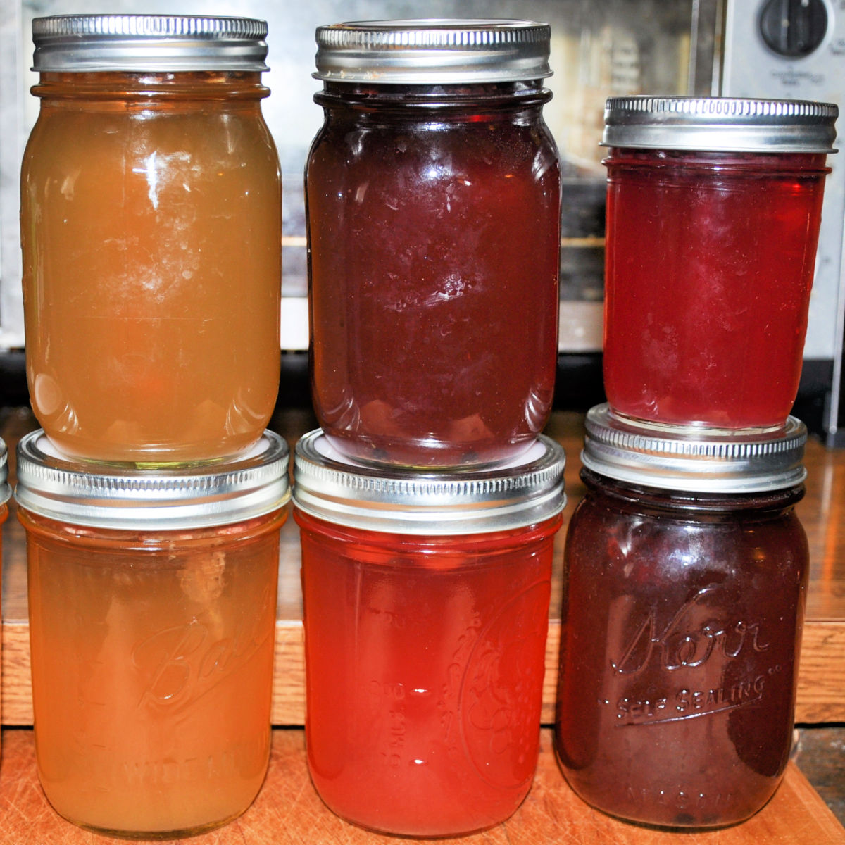 6 mason jars of different colored kombucha.
