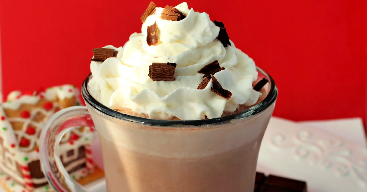 Frozen hot chocolate in a mug on a white platter with a red backdrop