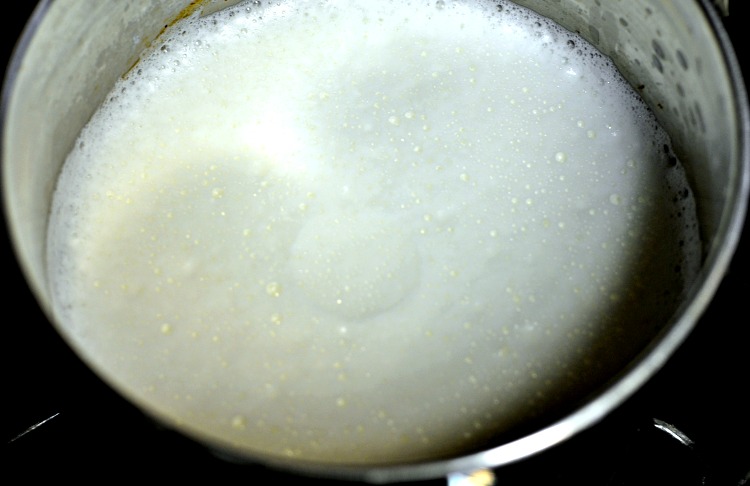 Milk simmering in a small saucepan