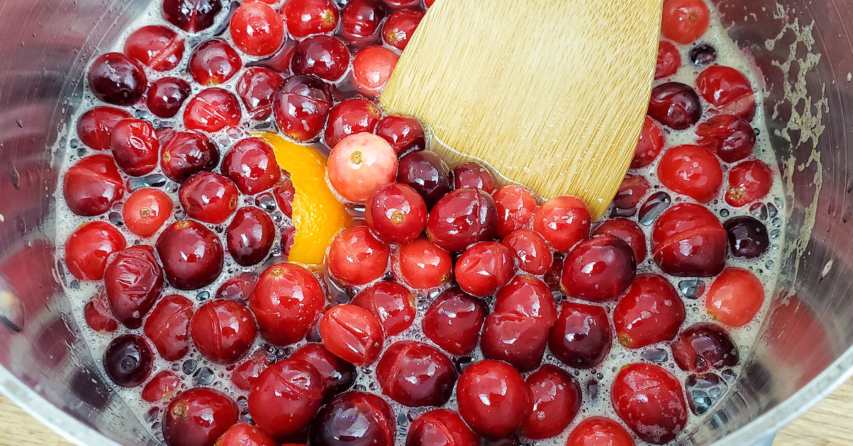 Cranberries popping in a saucepan to make cranberry sauce.