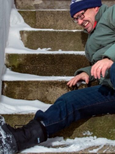 man slipping on icy front porch stairs