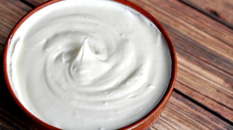 Close up of bowl of homemade sour cream that's super thick.