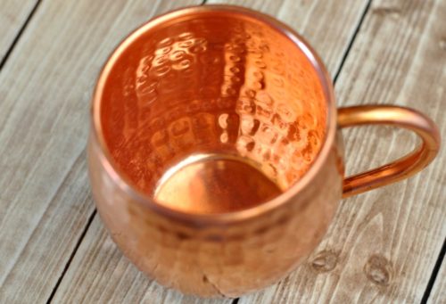 Clean copper mug on a light wood table