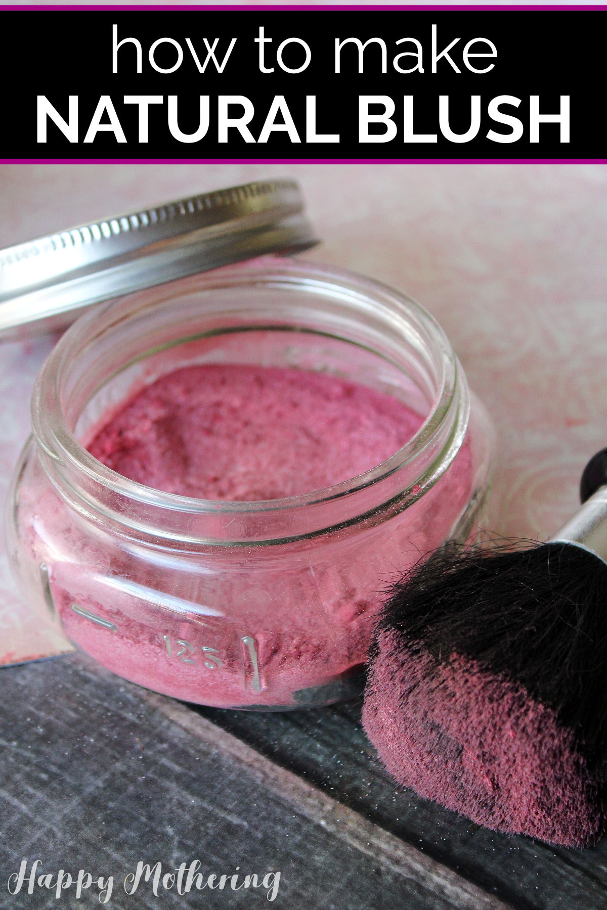 Jar of DIY blush on a table with a blush brush dipped in it ready to use