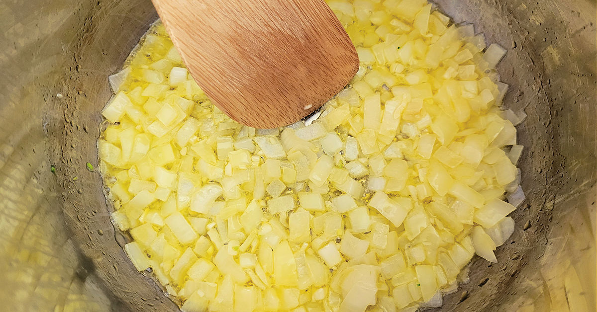 Onion and garlic being cooked in butter on Saute in an Instant Pot.