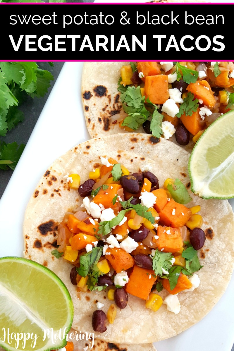 Three black bean and sweet potato tacos on a white rectangular plate with half a lime