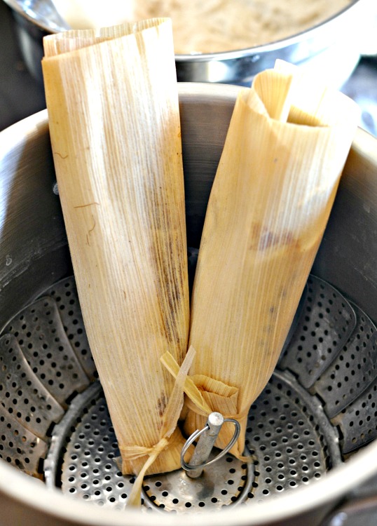 Tamales placed open side up in steamer pan