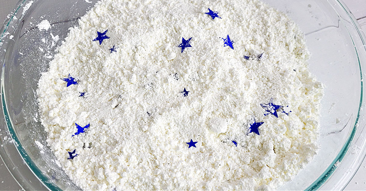 Blue star shaped confetti mixed into homemade fake snow.