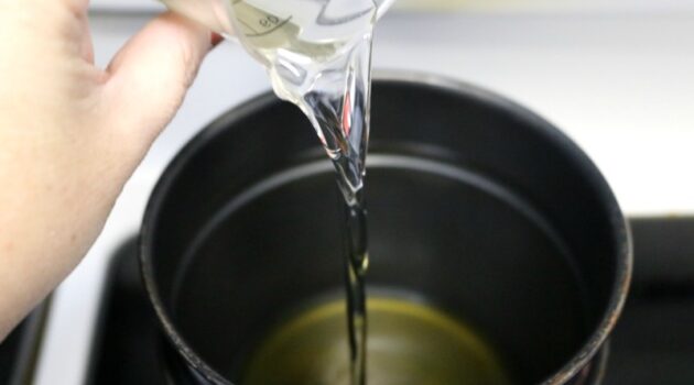 Coconut oil being poured into a double boiler pan