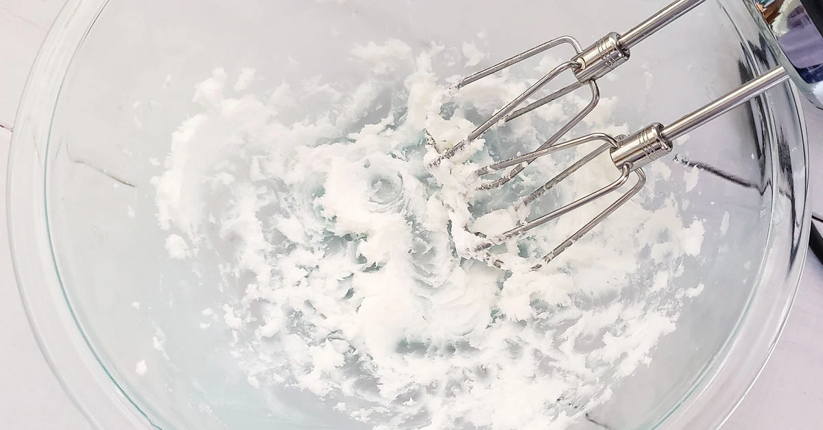 Chilled coconut oil being whipped with a hand mixer.