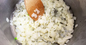 Onion being sauteed in a sauce pan.