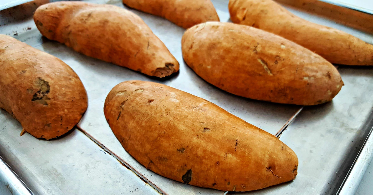 Sweet potatoes roasting on baking sheet.
