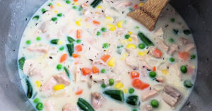 Cornstarch slurry mixed into chicken and veggies in sauce pan.
