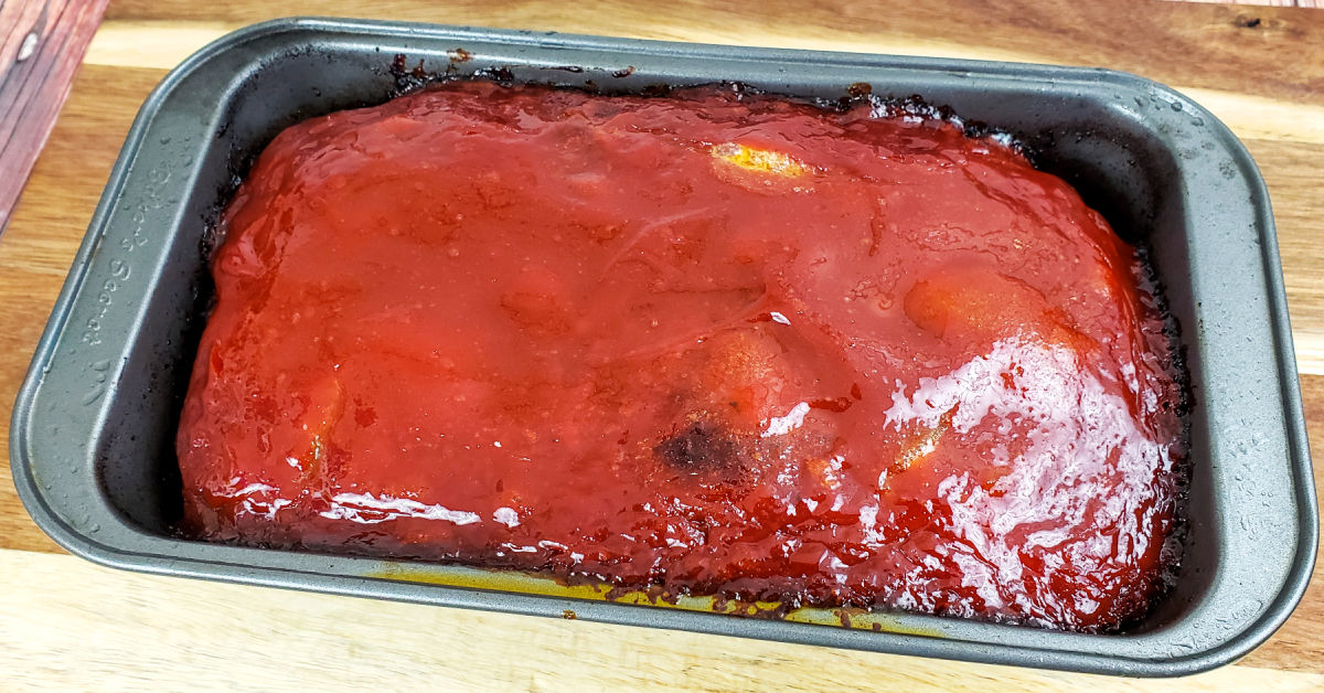 Fully baked gluten free meatloaf cooling on cutting board.