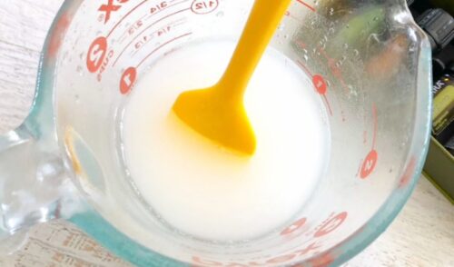 Natural toilet bowl cleaner in a glass mason jar with yellow silicone spatula.
