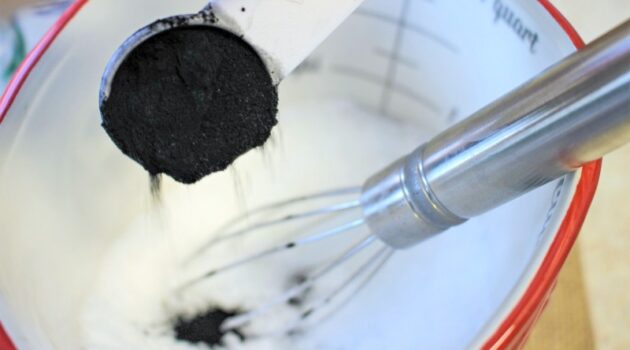 Adding activated charcoal powder to detox bath soak