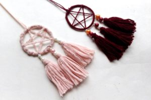 Two dreamcatcher necklaces on a white table