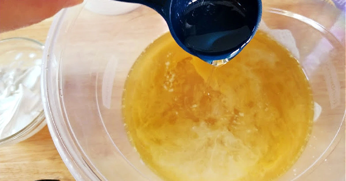 Adding oils to melted wax in bowl.