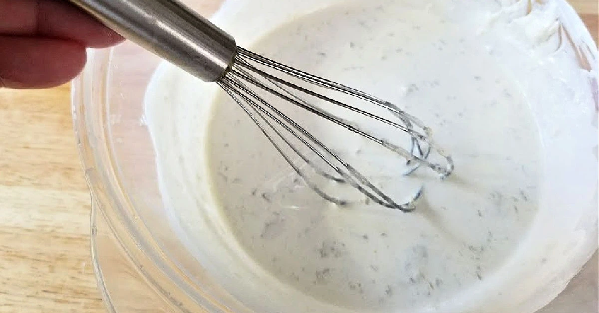 Homemade sunscreen ingredients in a mixing bowl with whisk