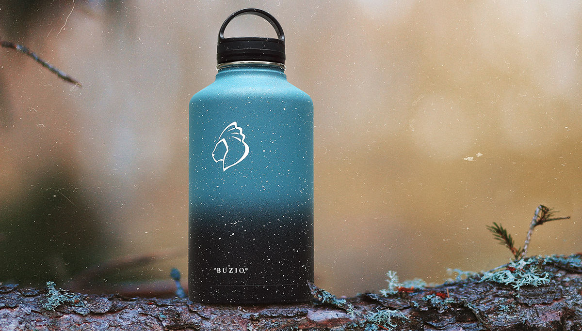 Blue and black Buzio water bottle on a log.