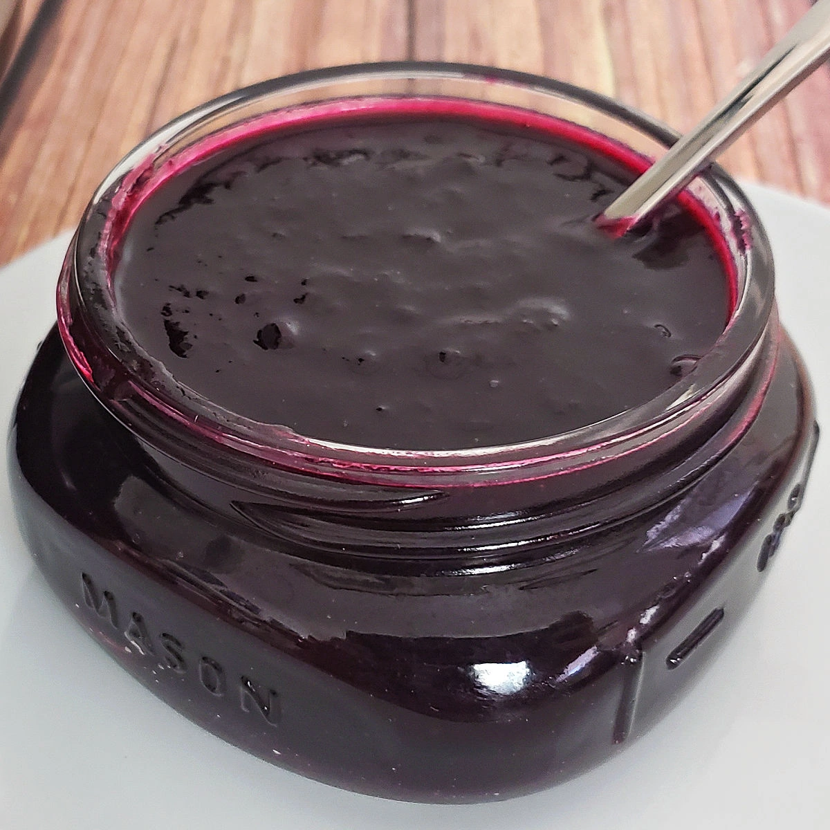 Half pint jar of homemade Instant Pot blueberry jam with spoon.